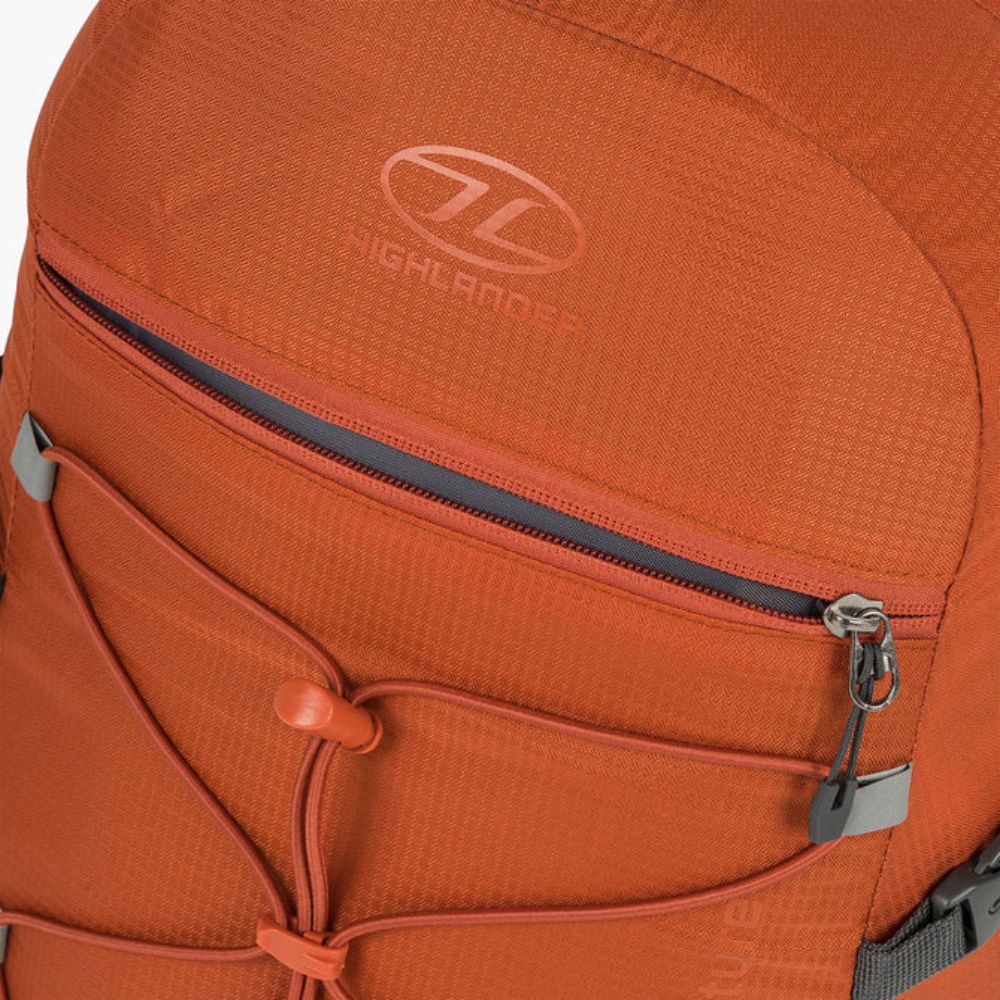 Zippered pocket detail on Venture Backpack 20L in rust/grey.