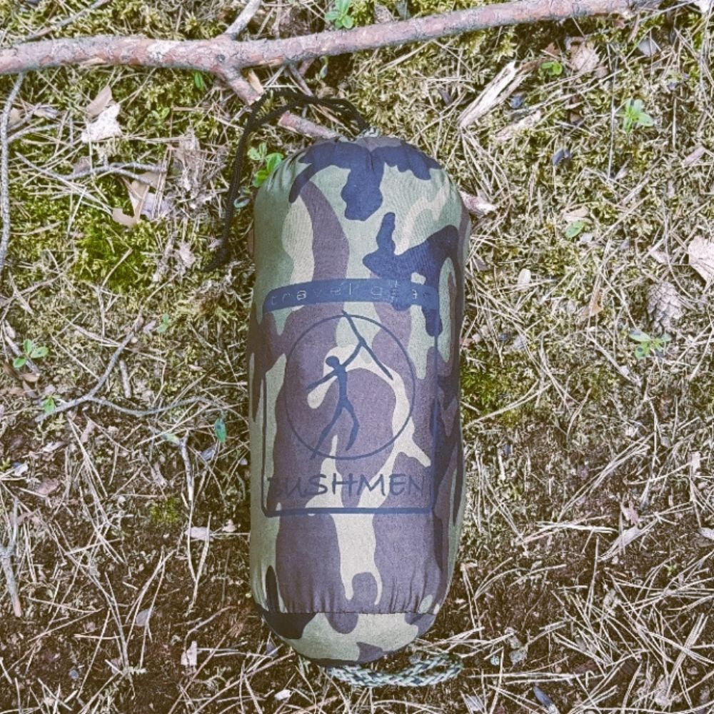 Camouflage storage bag for the hammock on grassy ground.