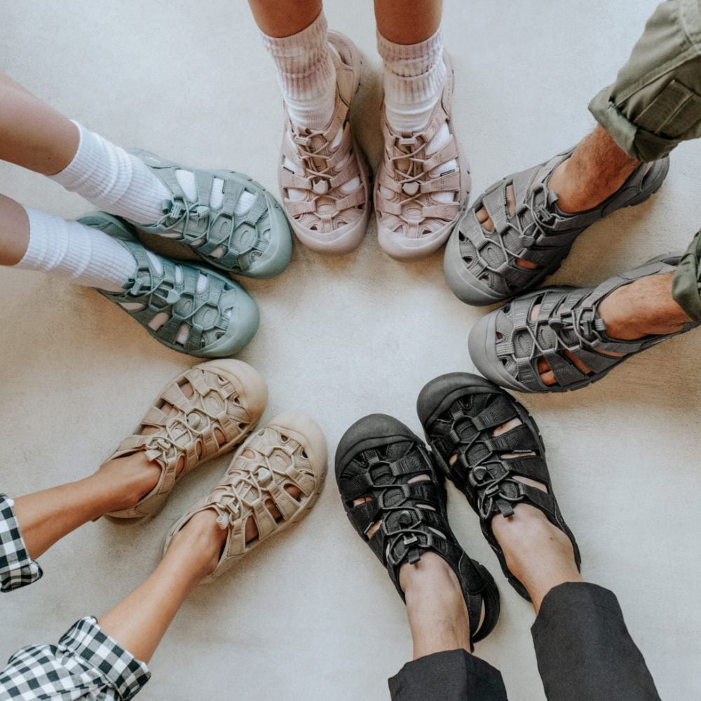 A circle of feet wearing KEEN Newport H2 sandals in various colors.