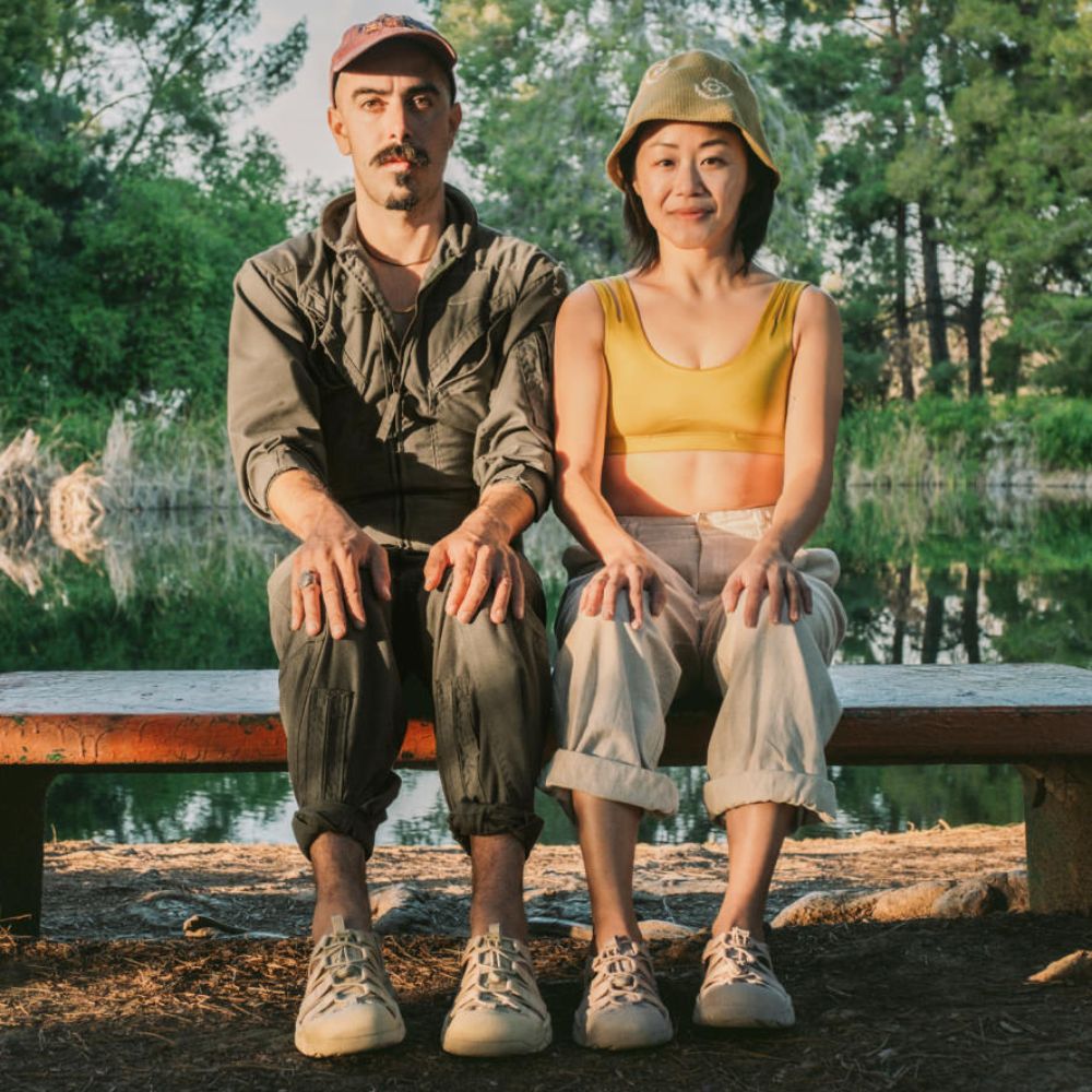 A man and a woman wearing Keen Newport H2 sandals in the Monochrome Safari colorway.