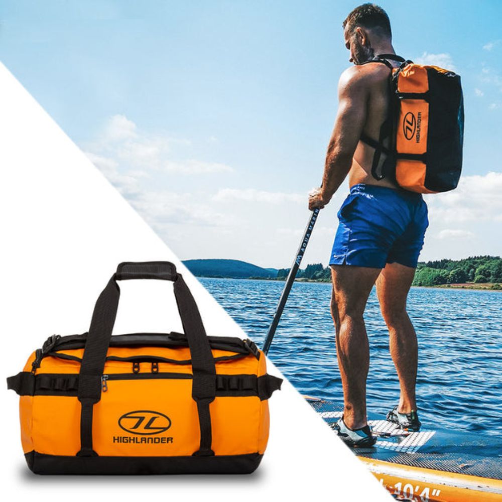 Man paddle boarding with Storm Kitbag Duffle in orange.