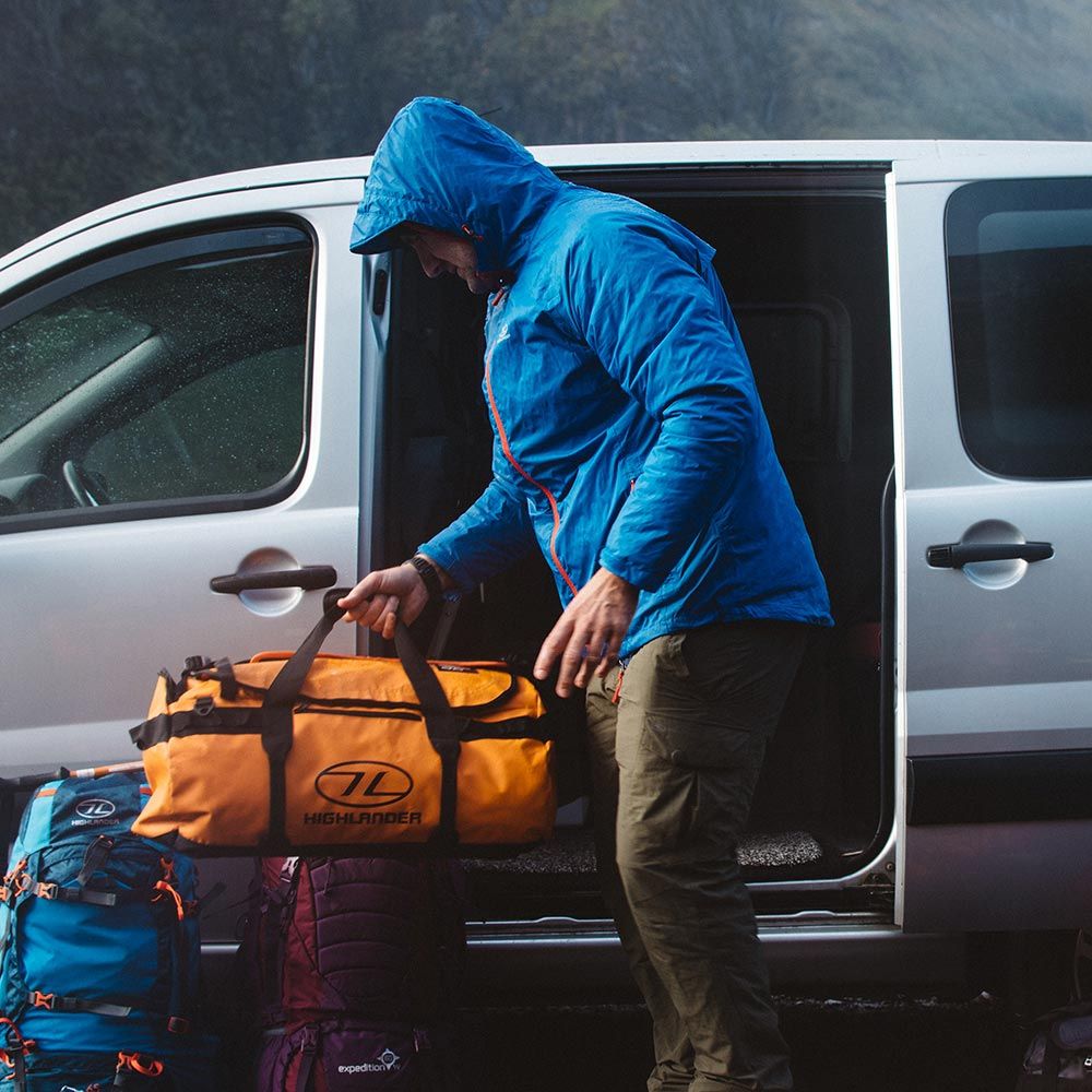 Storm Kitbag Duffle in orange being loaded into a van.